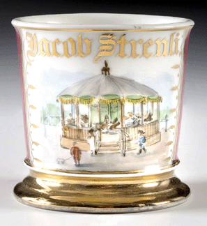 A shaving mug, gilt name Jacob Strenli, depicting a carousel with children, sold for $11,500.