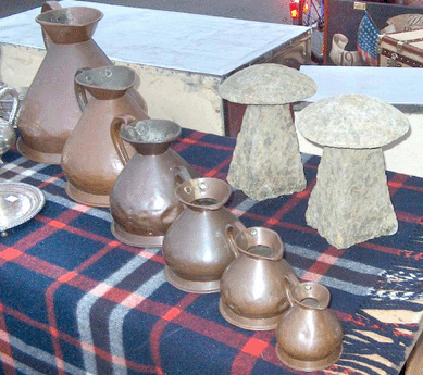 The copper pitchers were measures that would have been used in a dairy, and the stone objects, called staddle stones, were used to prevent vermin from getting into grain bins. The Finishing Touch, Hexham