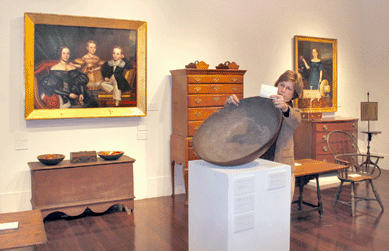 New Hampshire dealer Gail Piatt examines the magnificent burl bowl that H.F. du Pont kept at his Long Island house, Chestertown. Estimated at $25/35,000, it sold to New York dealer Leigh Keno for $181,000. Left, John S. Blunt's masterwork of circa 1834″5, $157,000, with portraits of four members of the Willard family. Patriarch Henry Haskell Willard is depicted in the miniature held by his wife. Blunt died at sea shortly after completing the commission. Below is a Connecticut River Valley blanket chest, $11,875.