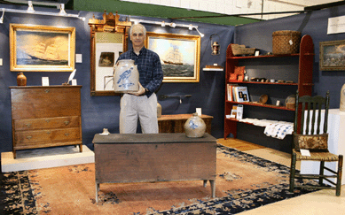 Steve German of Mad River Antiques, North Granby, Conn., holds a four-gallon stoneware jar, $1,750, decorated in cobalt with a turkey.