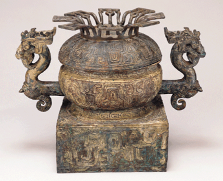This bronze vessel, or gui, was used for serving food during rituals. The handles, depicting dragons with tigers crouching on their necks, were lost wax castings requiring several ceramic molds; 12¾ inches tall, 15½ inches wide. 