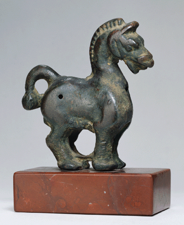 The short legs, stubby body, knotted tail and arched neck of this small bronze horse date it to the Eastern Han period (25′20 BC); height 2 3/8 inches, length 2 1/8 inches, width 5/8 inch. 