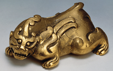 This Bixie, made of gilt bronze, was a protective beast, one of the many that lined the paths to tombs. It is attributed to the Western Han period (206 BC‹ AD); 1½ by 3 5/8  by 2¼ inches. 