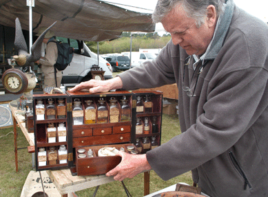 Newburyport, Mass., dealer Paul DeCoste shows the drawer in this circa 1830 medical box, which has a sliding panel on the back that hides the storage place for poisons. ⁊&J Promotions.