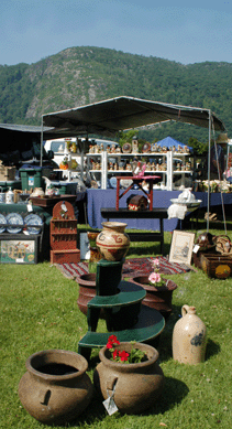 A pre-Columbian vase atop a three-tier lawn circle is displayed along with double glazed Mediterranean planters at All Your Yesterdays, Pound Ridge, N.Y., whose booth offered spectacular views of the Hudson Valley mountains.