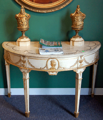 A pair of Adams-style console tables with marble tops and inlaid with fans, urns and swags sold on the phone for $13,800. The pair of 18-inch Louis XVI gilt bronze cassolettes on marble bases brought $1,840.