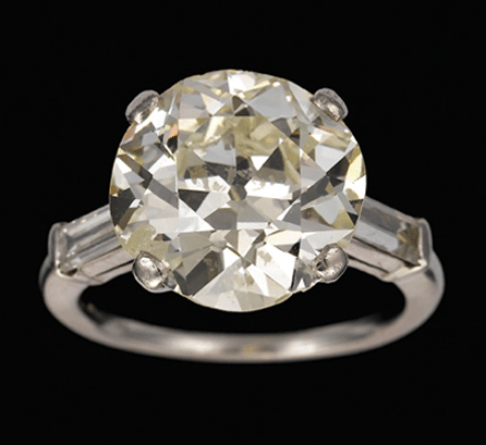 Early Twentieth Century platinum and diamond ring, with large round diamond, approximately 8.24 carats, flanked by baguette diamonds of approximately .12 carat each; it brought $145,000.