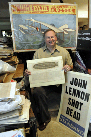One man, so many stories. Eric Caren's sense of history is not limited to only one period. Here, he holds an original of the famous Remarks on the Slave Trade, which graphically dramatized conditions on slave ships. To the right, a headline louder than the shot that killed John Lennon. Behind, a more joyful poster shouts out news of an early air show.