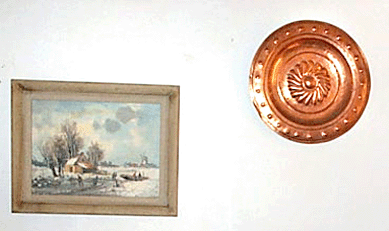 Winter scene painting in a white frame and copper charger.