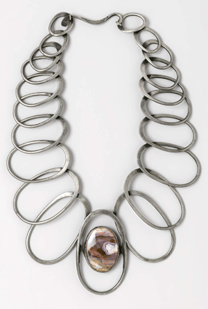 The "Linked Oval†necklace, also called the "Elegant,†was designed in 1974. The linked silver ovals reach a crescendo, terminating in a polished oval amethyst quartz stone.