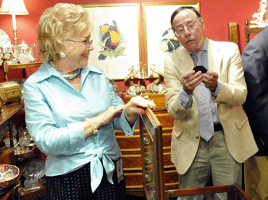 Sally Kaltman, Sallea Antiques, New Canaan, Conn., shows a client a box during preview.