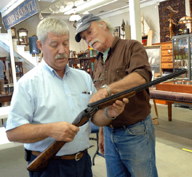 The rare Browning Arms Midas grade 28-gauge shotgun, shown here being examined at preview by Andre Drolet, left, assistant auctioneer, and patron Bill Hopkins, went to a private buyer in a phone bid for $16,500. ⁗.A. Demers photo.