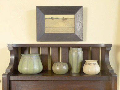 Bookcase with Marblehead Pottery vases and a Marblehead scenic motto tile after Arthur Wesley Dow. ⁁llen Phillips photo/Wadsworth Atheneum