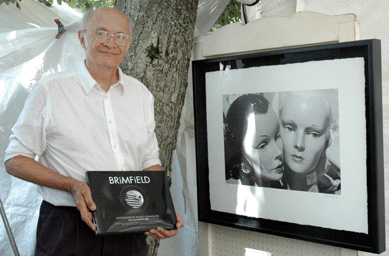 Photographer Angelo Dounoucos with a copy of his newly published photo-essay book, Brimfield, alongside an enlargement of one of the black and white images featured in the 128-page volume. ⁈ertan's 