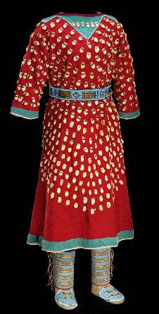 A circa 1890 Apsaalooke (Crow) cotton muslin dress is vibrant in red and green wool with elk teeth and seed beads. The dress was made in Montana. The V-neck alludes to the animal's tail.