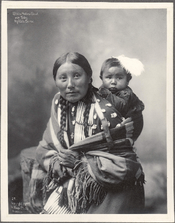 A photograph of Oglala Lakotan Stella Yellow Shirt and her baby, circa 1899, made in Omaha, Neb., by Frank A. Rinehart or Adolph F. Muir.