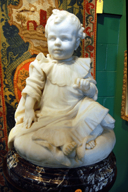 A carved white marble figure of an exceptionally sweet faced child was stamped "Roma 1905†and realized $14,950. 