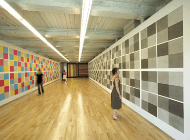 Installation of "Sol LeWitt: A Wall Drawing Retrospective.†Left, "Wall Drawing 413,†"Drawing Series IV (A)†with color ink washes (24 drawings), color ink wash, first installed March 1984 LeWitt Collection, Chester, Conn. Center, partial view, "Wall Drawing 681C,†wall divided vertically into four equal squares separated and bordered by black bands; within each square, bands in one of four directions, each with color ink washes superimposed, first installed August 1993. National Gallery of Art, Washington, D.C., Dorothy and Herbert Vogel collection, 1993. Right, "Wall Drawing 414,†"Drawing Series IV (A),†with India ink washes, 24 drawings, first installed March 1984 LeWitt collection, Chester, Conn.  ⁋evin Kennefick photo