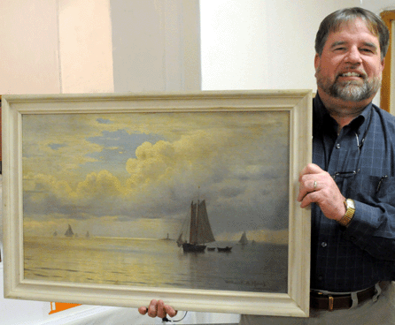 Auctioneer Tim Gould with the top lot of the auction, a marine painting by William Frederic de Haas, picked from a New Hampshire Lakes Region home. It sold to a phone bidder for $39,600.