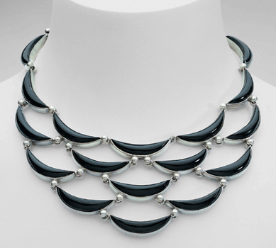 A silver and onyx necklace set with crescent shapes.