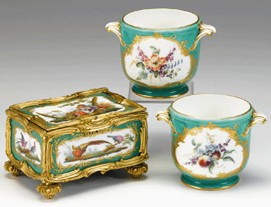 A pair of Sevres-style porcelain cache pots, Nineteenth Century, with molded foliate scroll handles and floral reserves on an apple green ground, with gilt details throughout, blue interlaced marks to bases, realized $34,600.
