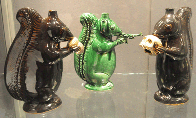 Michelle Erickson, Yorktown, Va., studies antique objects and then reproduces them, adding her own whimsical touches. In the case of the reproduced Moravian squirrel-form redware bottles, "Second Amendment Squirrel†is depicted with a machine gun in its paws, while "Nut Squirrel†chews on the wrong end of an acorn and "Skull Squirrel†nibbles on a human cranium.