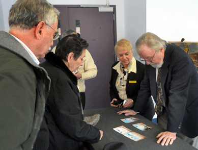 Gene Shannon, right, and Vivien Cord look over a piece of artwork at the show. Shannon provided appraisals.