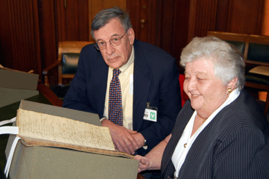 Kemble Widmer and Joyce King inspect the pages of one of Nathaniel Gould's waste books. Each of Gould's clients had his own detailed ledger page or pages that noted the object, the wood and sources, and sometimes the reason for the purchase.