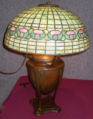 Tiffany Studios leaded stained glass mushroom shade, 16 inches in diameter, on an urn base, went to $16,100.
