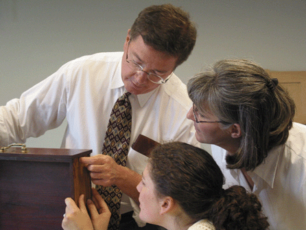 At a furniture workshop for the 2003 class of the Historic Deerfield Summer Fellows at the Flynt Center of Early New England Life, Phil Zea and two fellows examine a dovetailed drawer.