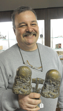 Auctioneer Glenn Ralston with the bronze pattern for the North Pole bank that sold for $8,736.