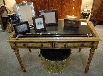 At C.M. Leonard Antiques, South Salem, N.Y., this English writing table, circa 1860‱880, intricately figured in pollard oak, held a pair of antique walking sticks and photo frames crafted from the underbelly of an alligator.