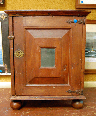 The pine spice cabinet on hardwood feet in red wash with a mortised and pegged door with a recessed mirror and spade form hinges went on the phone for $8,050.