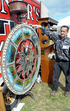 Keith Meissner with a large horse race wheel. Meissner's Antiques, New Lebanon, N.Y.