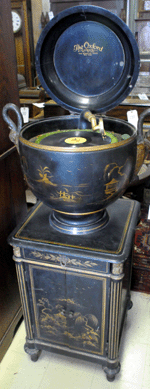 An unusual floor-standing record player in the shape of an urn, with stork-head handles atop a cabinet, made by the Mundler Corporation, realized $3,220.