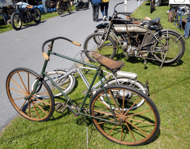 Old bikes do not always have engines. The Elliot Hickory bike from about 1880 had wooden wheels and was all original except for a very old repaint. Behind it, standing, is a 1914 Pope in original condition. Both were displayed by David Leitner, Auburn Hills, Mich.