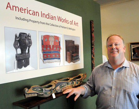 Auctioneer Colin Stair with the Northwest Coast Kwakiutl model of a feast dish, attributed to Charlie James, that sold for $4,025.