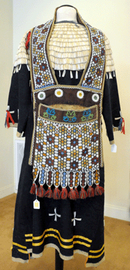 The Great Lakes bandolier bag, displayed on top of the dress, sold at $1,265; the Sioux woman's dress with dentalium shells went for $12,650.