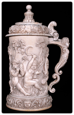 A Nineteenth Century Swiss carved and cross-hatched ivory tankard with a frieze of Bacchanalian putti realized $17,700.