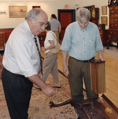 Ron Pook, left, and dealer Skip Chalfant give the "once over†to a lowboy in the sale. ⁁ntiques and The Arts Weekly photo, R. Scudder Smith