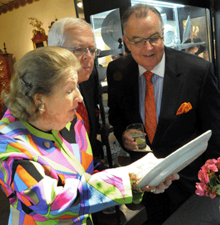 At the Ellis Antiques Show last October, Elinor Gordon, Villanova, Penn., shows clients one of a pair of French armorial plates that on careful inspection revealed the concealed image of Louis XVI.