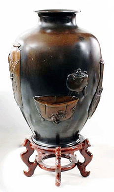 Superb Japanese patinated bronze vase, Meiji period (Nineteenth Century), signed, cast in relief with Kanon, samurai helmet, shi-shi, scrolls and various vases and jardinières, height 21 inches, went out at $4,800. 
