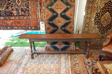 Rugs and carpets hung on the walls and nested on the floors looked like a Moroccan market at Interiors with Provenance, Amesbury, Mass. The carved walnut William and Mary bench provided seating.