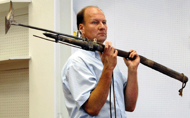 Paul J. Murphy, sales manager for Gustave J.S. White auctions, hefts the brass darting gun harpoon and bomb, mounted on the original 6½-foot wood pole, which sold for $4,200. 