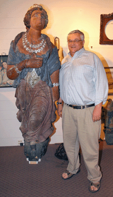 The big gal with auctioneer Ron Bourgeault is a carved and painted full-length figurehead from the ship White Lady. Sold to Hyland Granby Antiques of Hyannis Port, Mass., for $183,000, the sculpture belonged to the New Bedford Whaling Museum between 1926 and 2007, when it was deaccessioned. It is attributed to John Rogerson, a Scottish-born carver who immigrated to Boston in 1849. The bronze architectural eagle fetched $25,740; the China trade portrait of a woman, $819.