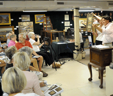 Auctioneer Kaja Veilleux looks for a final bid on the Eighteenth Century schoolgirl sampler.