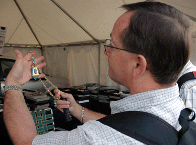 Lebanon, Penn., jewelry dealer Ken Sheldon carefully examines a necklace containing turquoise and pearls, circa 1840s‵0s †"probably a mourning piece,†he said †at the Midway booth of Jeff and Alberta Brown Antique Jewelry, East Hampton, Mass. During the July show, the Browns were elated to sell a case full of jewelry to a single dealer. Luck was with them again this year, as Sheldon purchased the Victorian necklace for a six-figure sum.