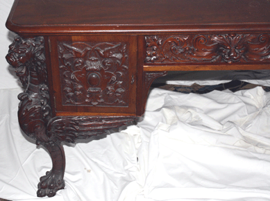 Detail of the elaborately carved mahogany partners' desk by R.J. Horner & Co. with Northwind faces, large gargoyles and claw feet that realized $4,068.