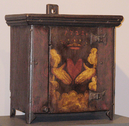 This hanging cupboard was made in New York or Middletown, N.J., dated 1722, of white oak and yellow pine. The image on the door signifies the Dutch saying, "A true heart is a crown of gold.†The cupboard descended in the Luyster family who settled in Monmouth County in 1717. It was a gift to the Monmouth County Historical Association from John R. and Alfred G. Luyster.