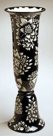 An elongated bell-form molded white earthenware vase with a black and white decoration, circa 1922, was made by Michael Powolny at the Gmundener Keramik for Wiener Werkstätte.